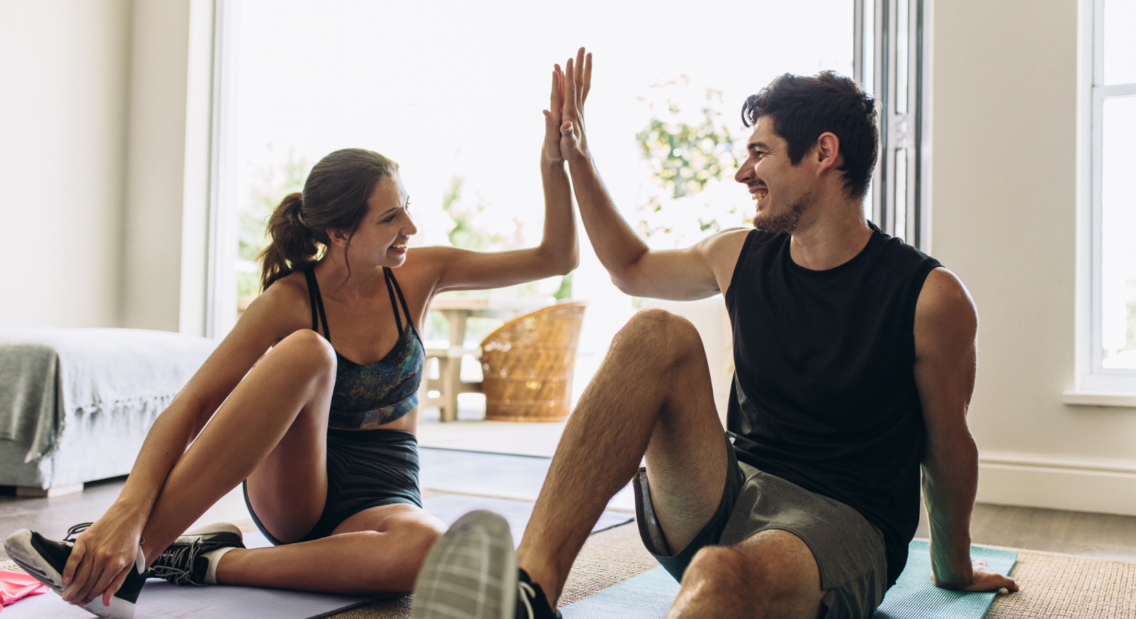 Man and woman sitting on floor at home working out