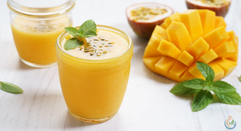 Delicious orang and yellow mango smoothie shake in glass on white table